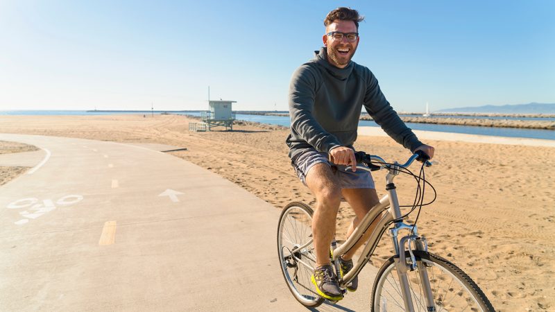 young-man-cycling-along-pathway-at-beach-2026-03-26-11-54-44-utc